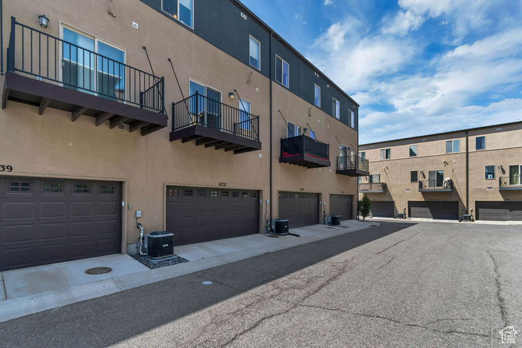 View of property with a garage and central AC unit