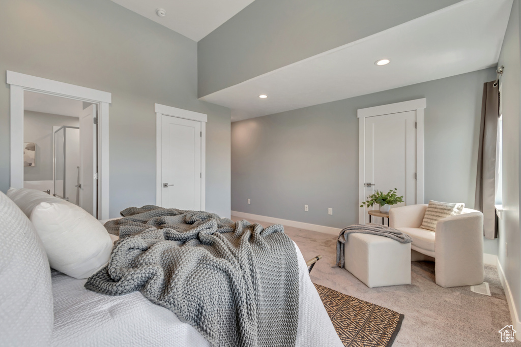 Bedroom with light colored carpet, recessed lighting, baseboards, and a high ceiling