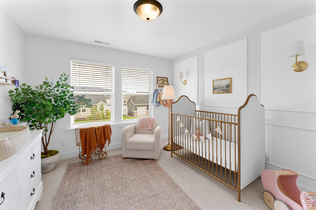 Bedroom with light carpet and a crib