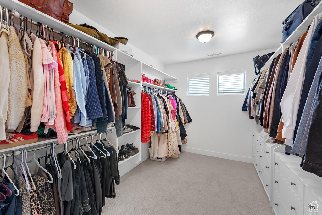 Walk in closet with light colored carpet