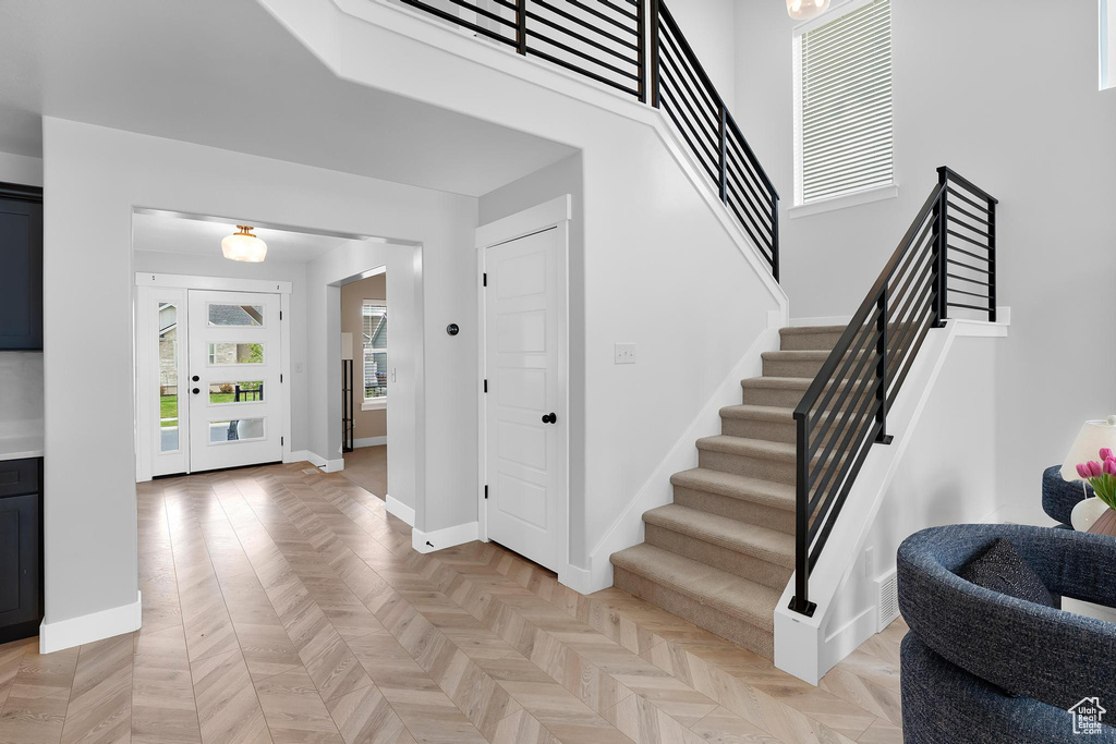Foyer entrance with stairway and baseboards