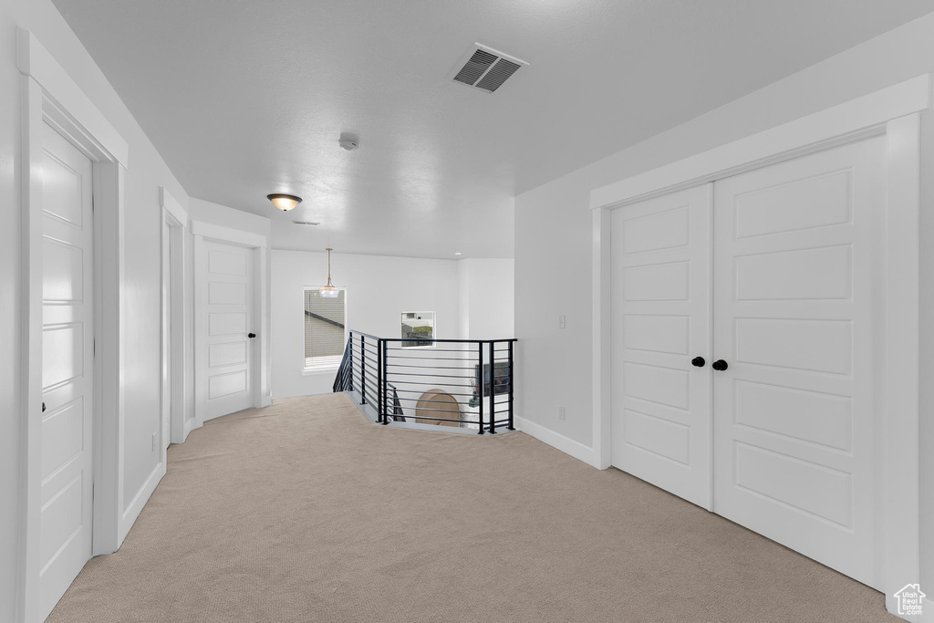 Hall featuring carpet floors, an upstairs landing, and baseboards