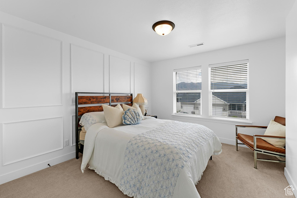 Bedroom featuring light carpet and baseboards
