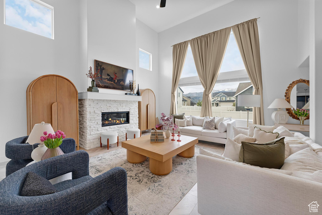 Tiled living area featuring a towering ceiling and a fireplace