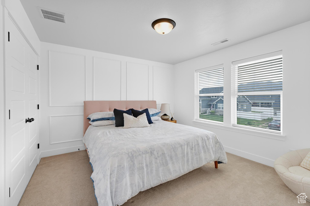 Bedroom with light carpet and baseboards