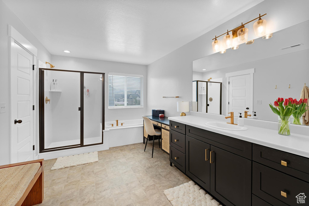 Bathroom with a stall shower, a bath, vanity, and recessed lighting