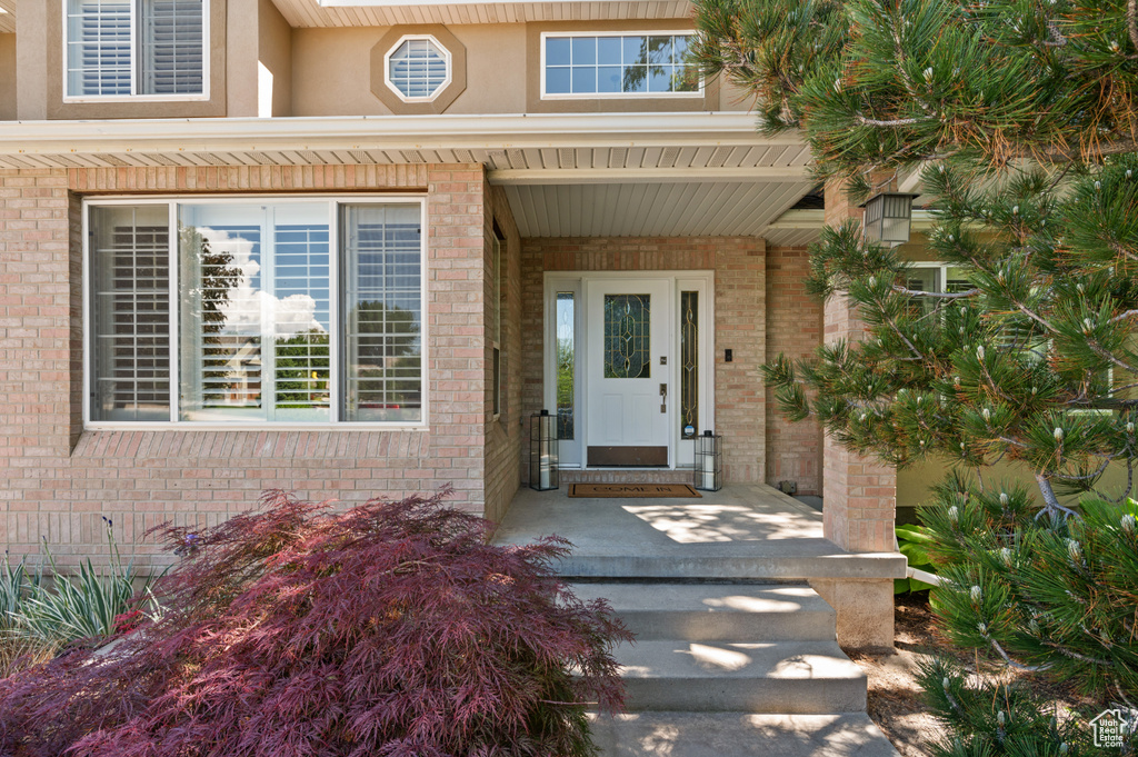 Property entrance with brick siding and a porch