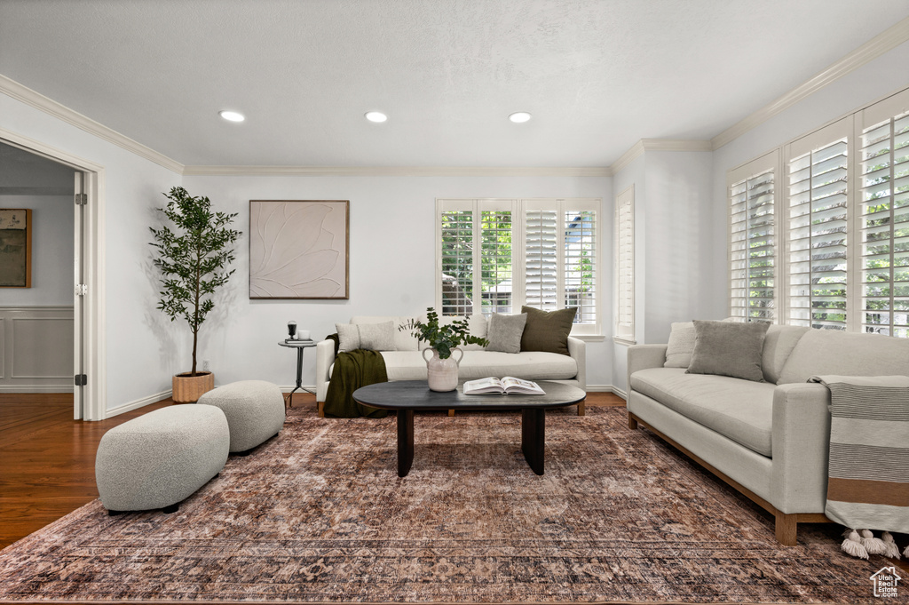 Living room with wood finished floors, crown molding, recessed lighting, and baseboards