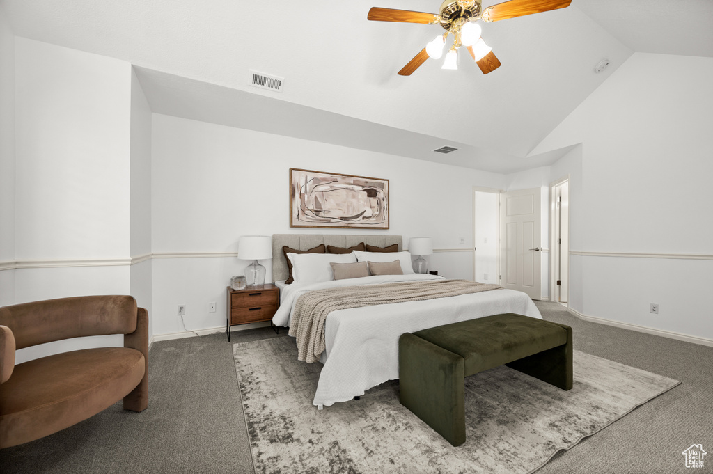Carpeted bedroom with ceiling fan, baseboards, and high vaulted ceiling