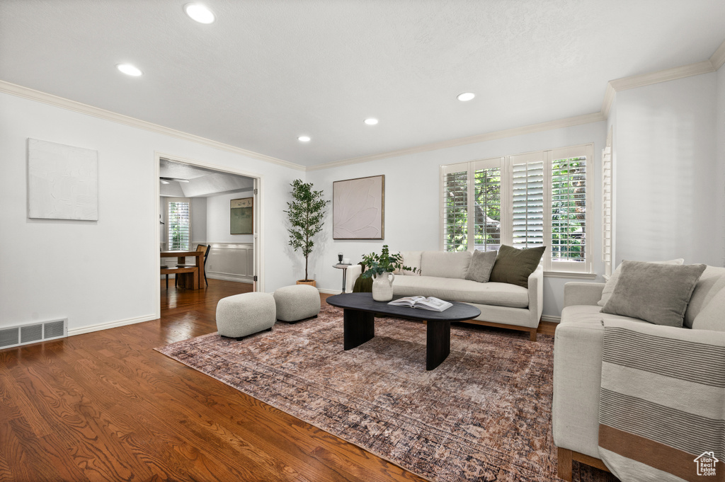 Living room with crown molding, wood finished floors, recessed lighting, and baseboards