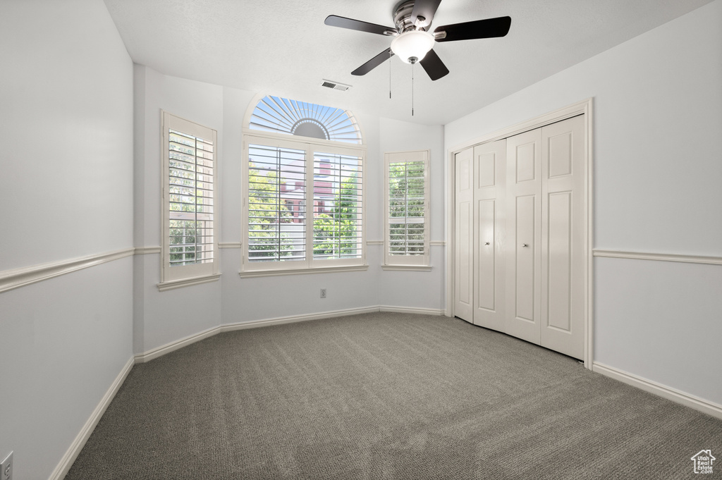 Unfurnished bedroom with carpet floors, baseboards, a ceiling fan, and a closet