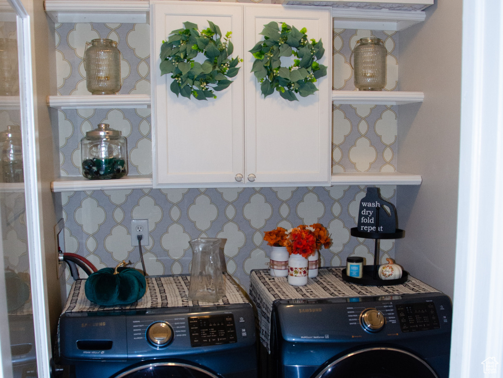Washroom with cabinet space, washing machine and clothes dryer, wood tiled floors, and a textured ceiling