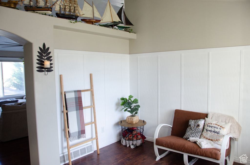 Sitting room with arched walkways and dark wood finished floors
