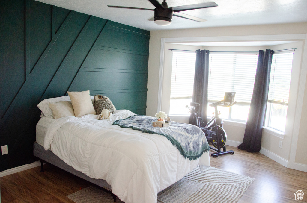 Bedroom with baseboards, light wood-type flooring, and ceiling fan