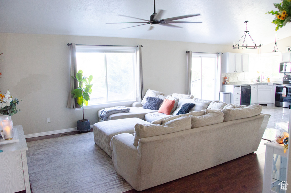 Living room with ceiling fan, beverage cooler, and baseboards