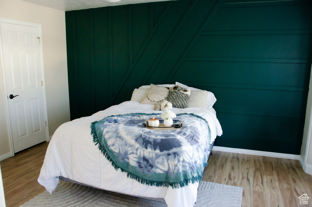 Bedroom with wood finished floors and baseboards