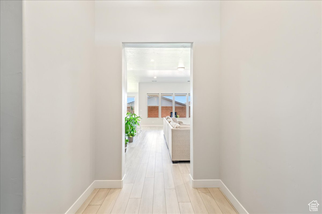 Corridor featuring baseboards and light wood-style floors