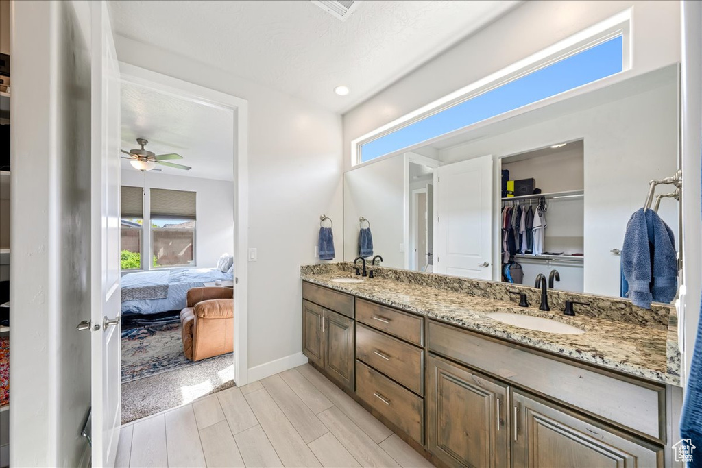 Ensuite bathroom with double vanity, ceiling fan, wood tiled floors, baseboards, and recessed lighting
