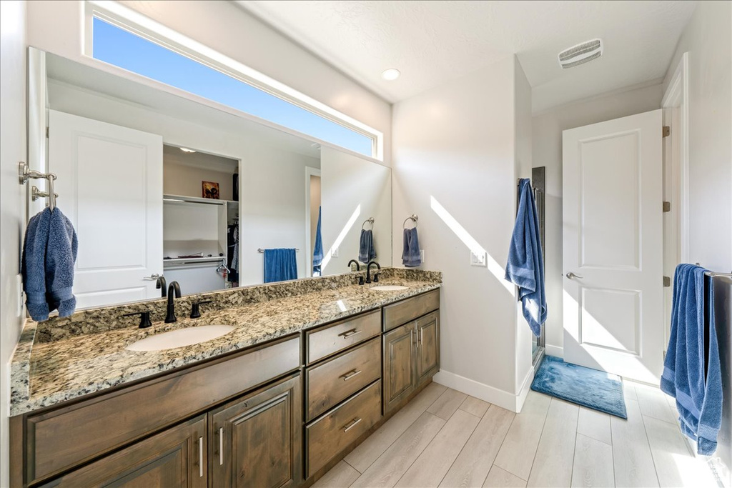 Full bathroom featuring double vanity, baseboards, and wood tiled floors