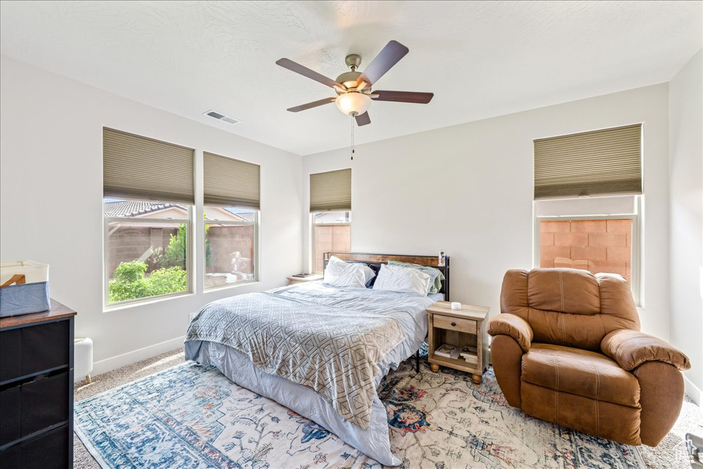 Carpeted bedroom with baseboards and a ceiling fan