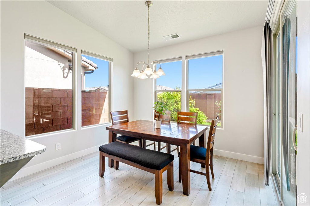Dining space featuring a chandelier, light wood-type flooring, and baseboards
