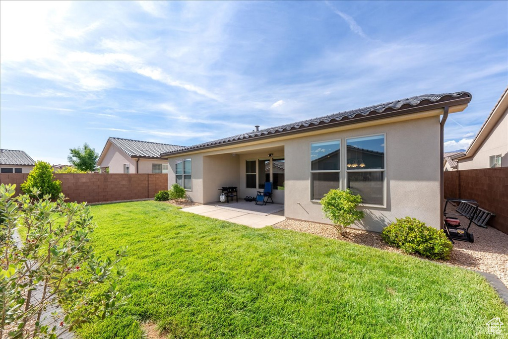 Back of house featuring stucco siding, a patio area, and a tile roof