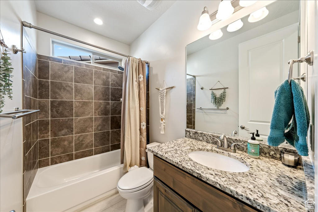 Full bathroom featuring shower / bathtub combination with curtain, vanity, and toilet