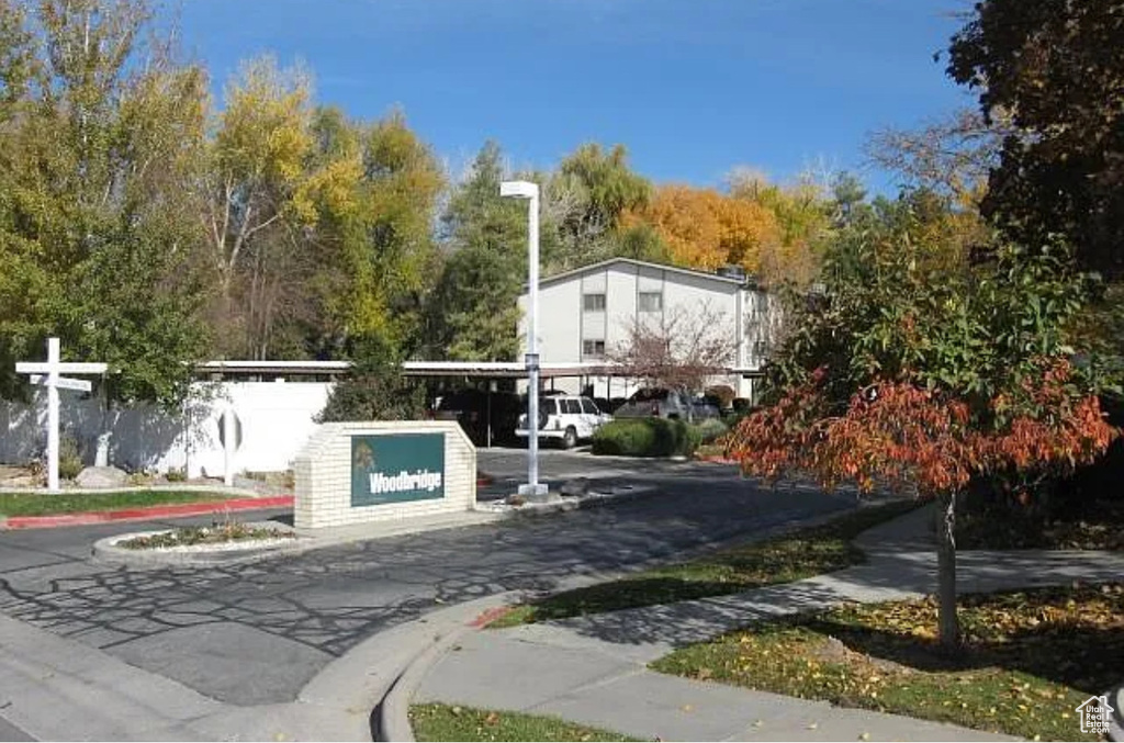 View of asphalt road featuring sidewalks and curbs