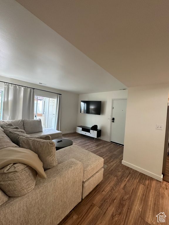 Living area with baseboards and dark wood-style flooring