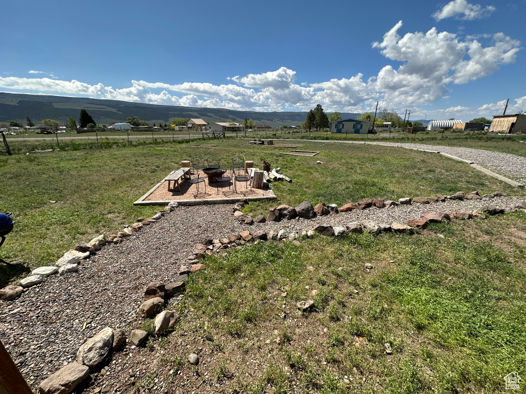 View of yard featuring a fire pit, a mountain view, and a rural view