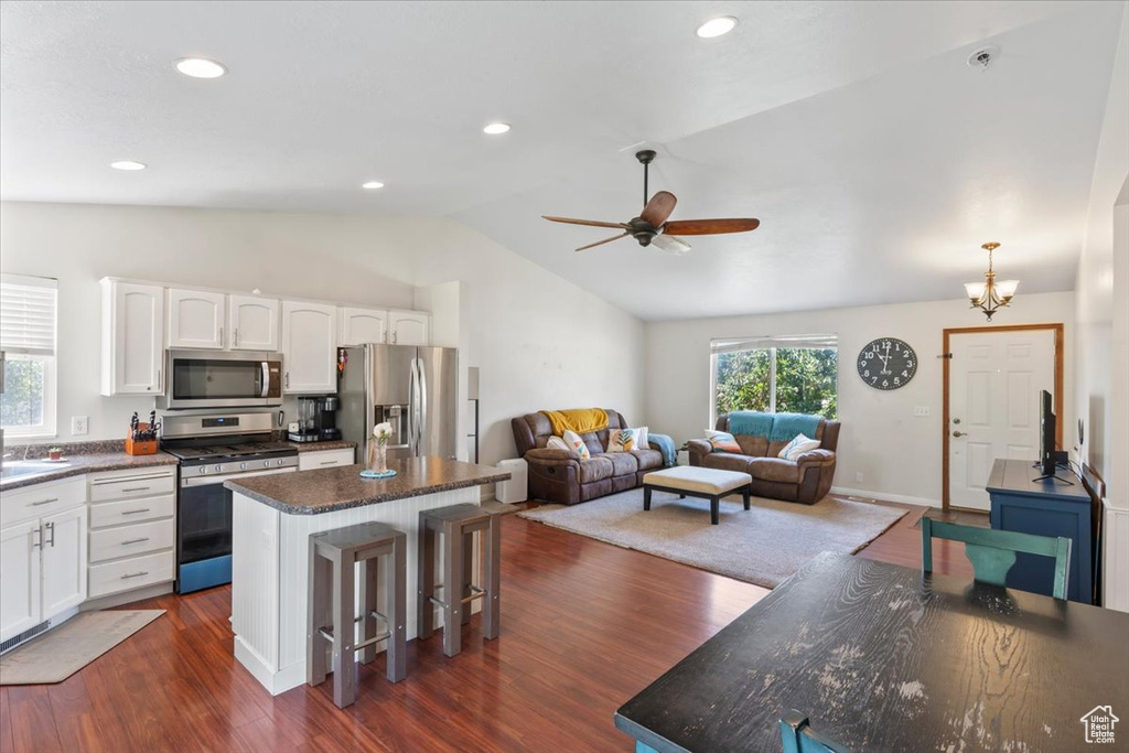 Kitchen with stainless steel appliances, lofted ceiling, a kitchen island, white cabinets, and a ceiling fan