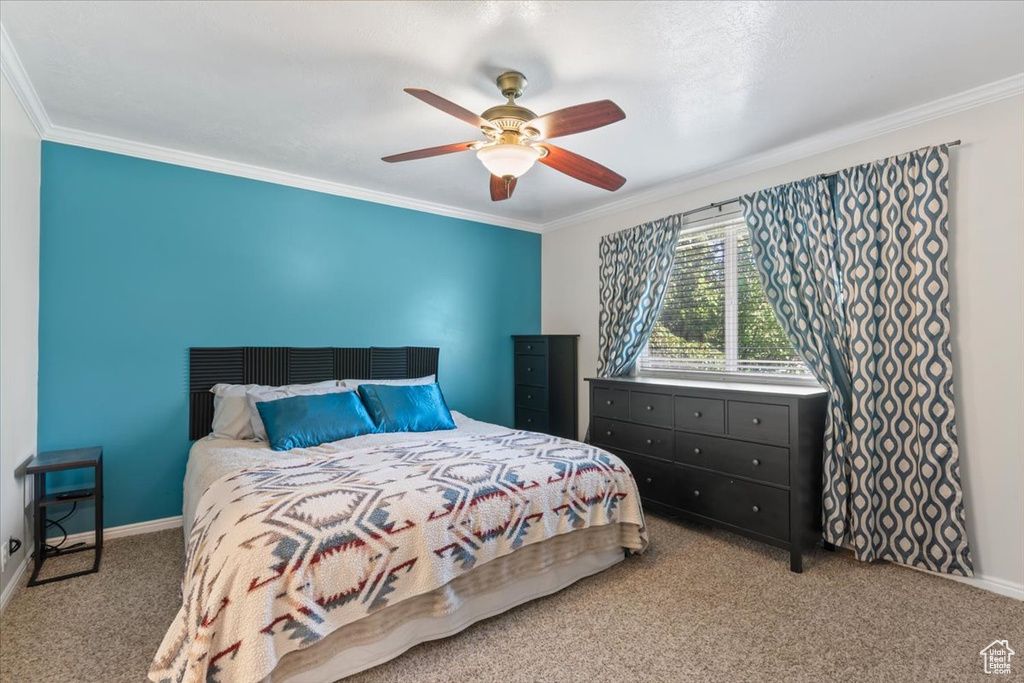 Carpeted bedroom featuring ornamental molding, baseboards, and ceiling fan