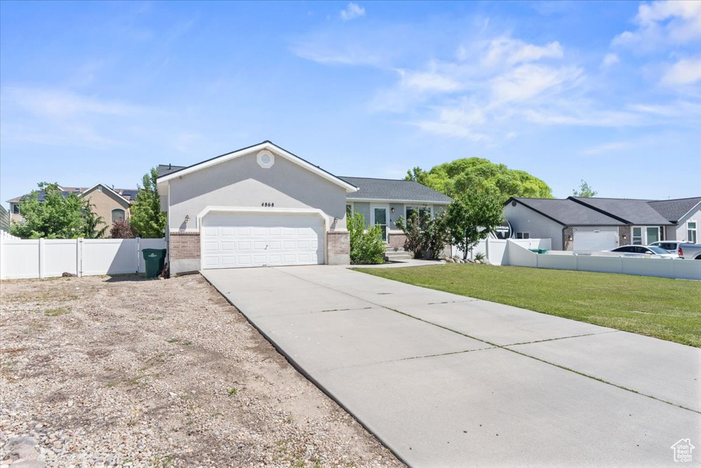 Ranch-style home featuring a garage, concrete driveway, stucco siding, and a residential view