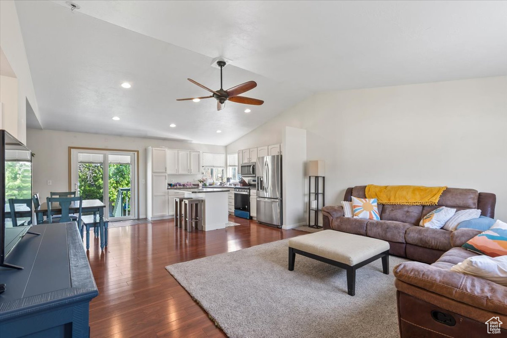 Living area featuring ceiling fan, vaulted ceiling, dark wood-style flooring, and recessed lighting