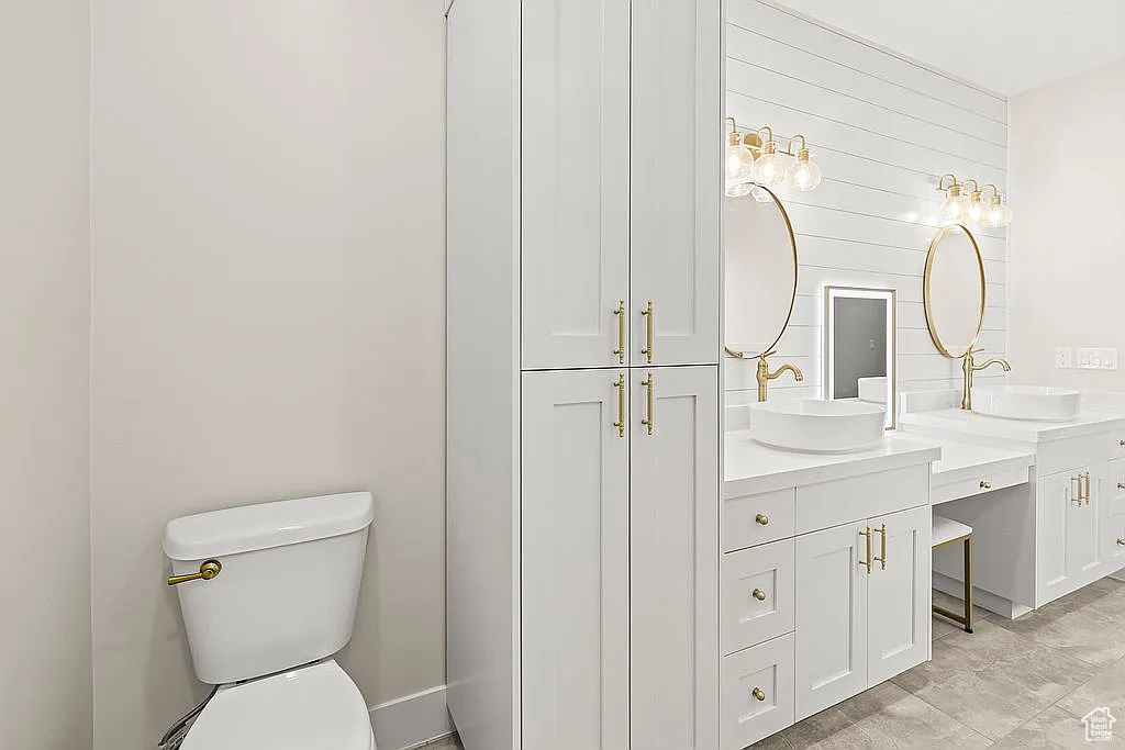 Full bathroom with double vanity and toilet