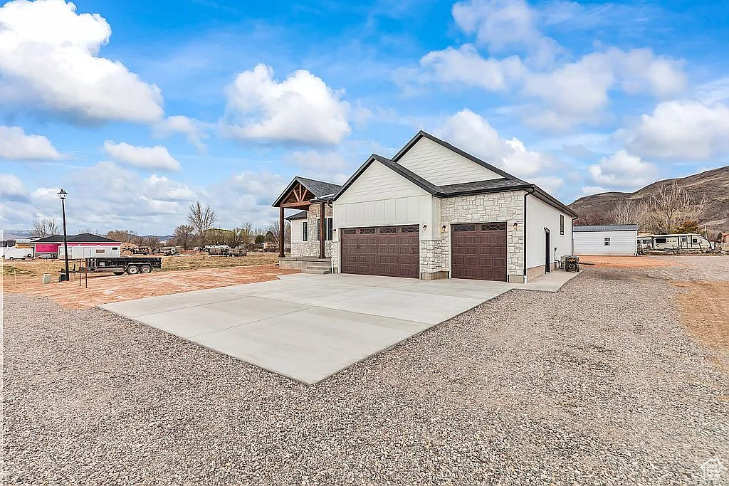 View of home's exterior featuring driveway, a garage, and stone siding