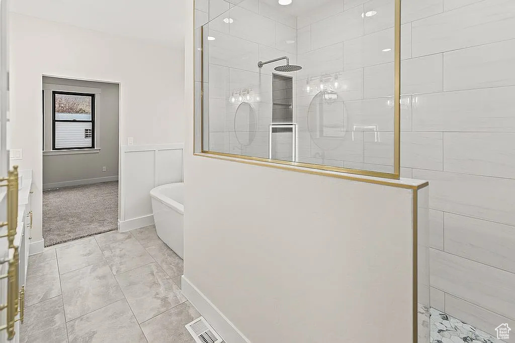 Full bath with a freestanding bath, walk in shower, and baseboards