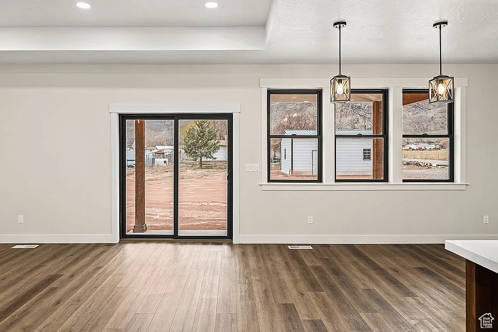 Unfurnished dining area with wood finished floors, baseboards, and recessed lighting
