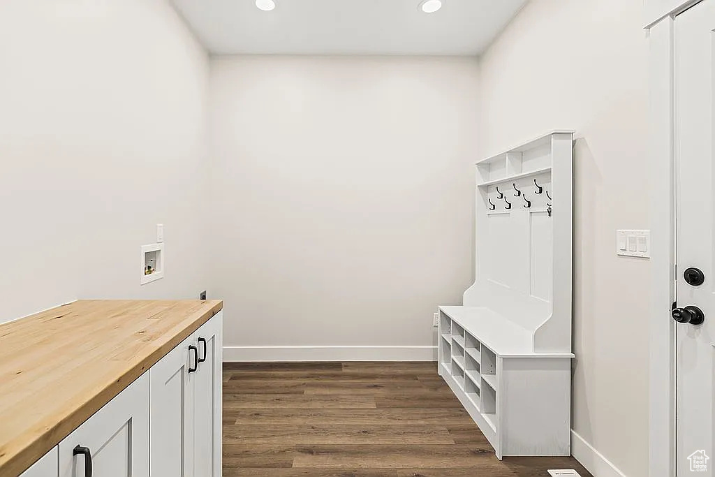 Washroom with cabinet space, hookup for a washing machine, baseboards, dark wood-style flooring, and recessed lighting