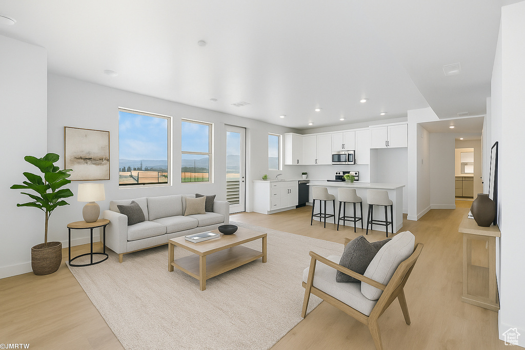 Living area featuring light wood-style flooring and recessed lighting