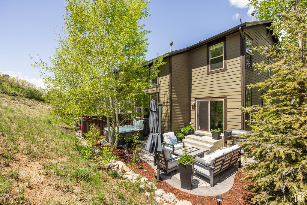 Back of property featuring an outdoor hangout area and a patio