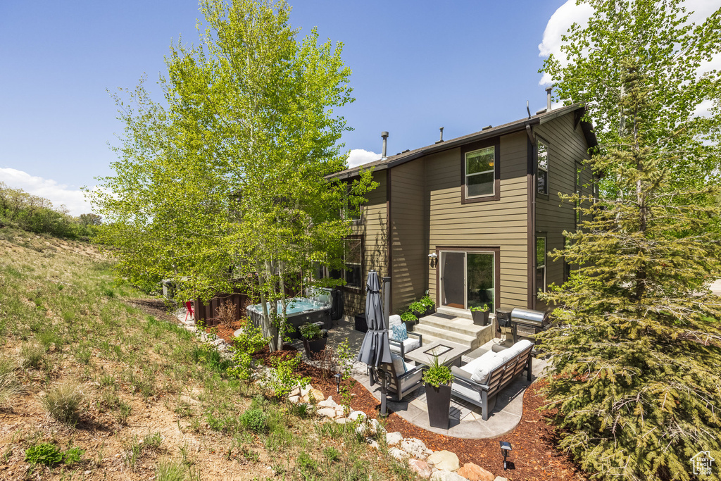 Rear view of property featuring a patio and an outdoor living space