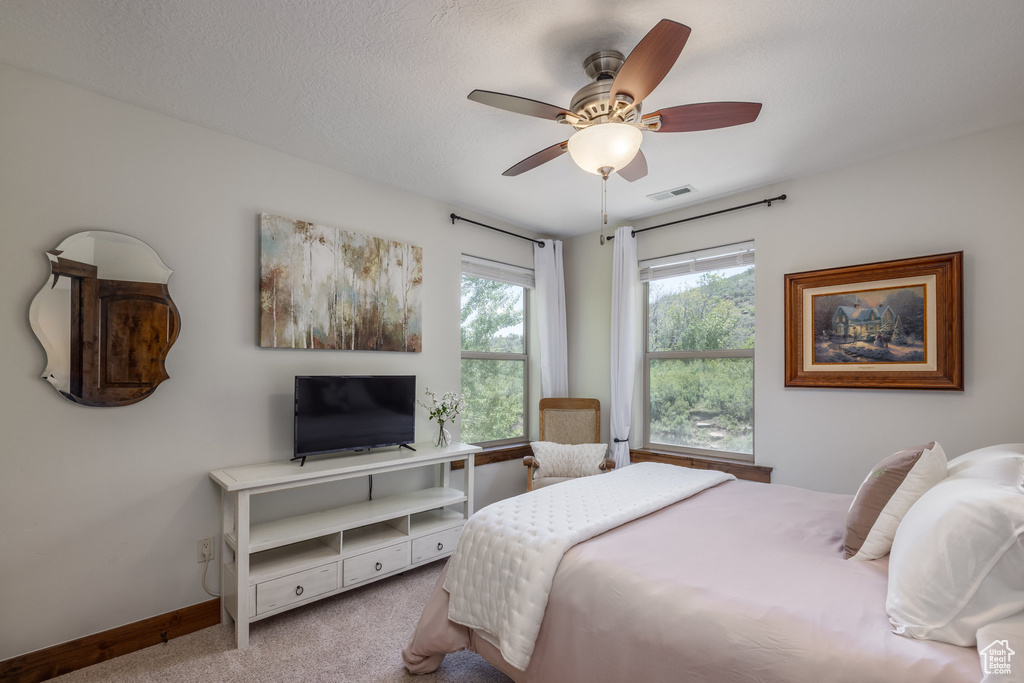 Bedroom featuring carpet floors, baseboards, and a ceiling fan