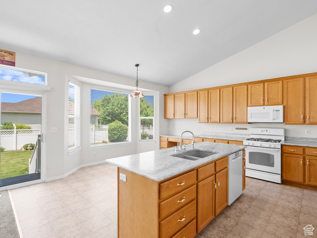 Kitchen with white appliances, a sink, vaulted ceiling, hanging light fixtures, and a kitchen island with sink