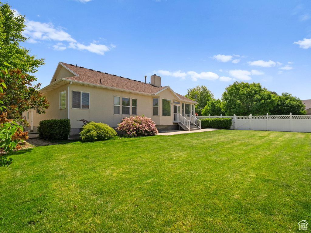 Rear view of house with stucco siding and a chimney