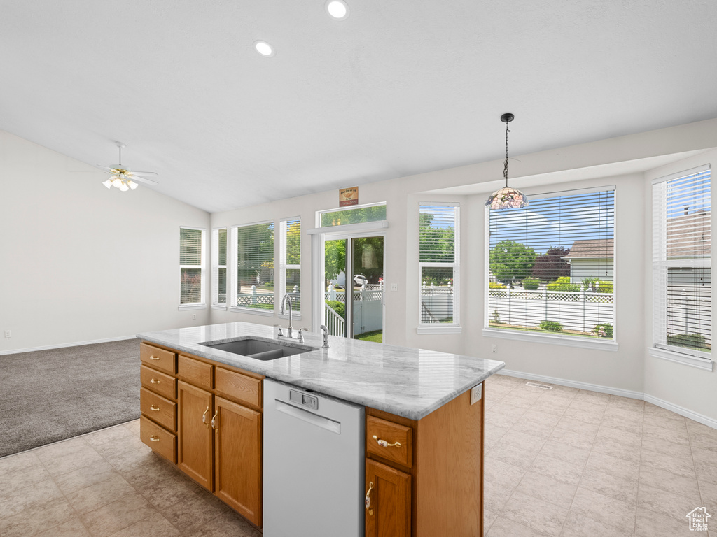 Kitchen featuring dishwasher, a sink, open floor plan, brown cabinetry, and lofted ceiling
