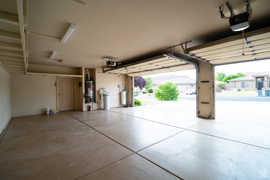Garage with gas water heater and a garage door opener