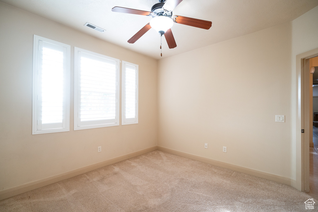 Unfurnished room with carpet flooring, baseboards, and a ceiling fan