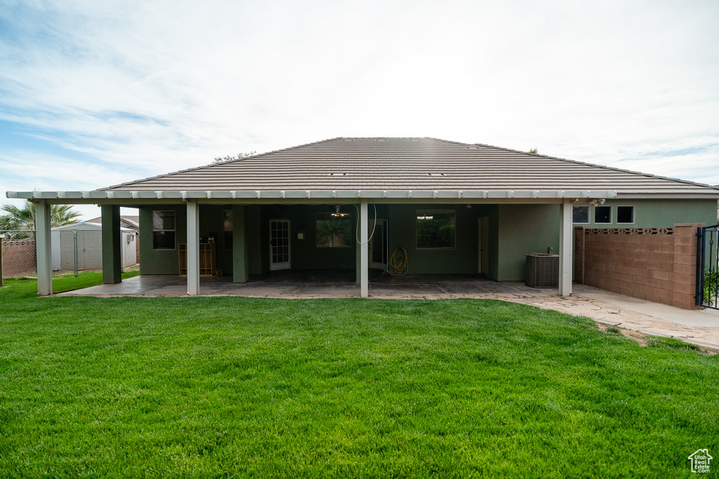 Back of property with a patio area, central air condition unit, and stucco siding