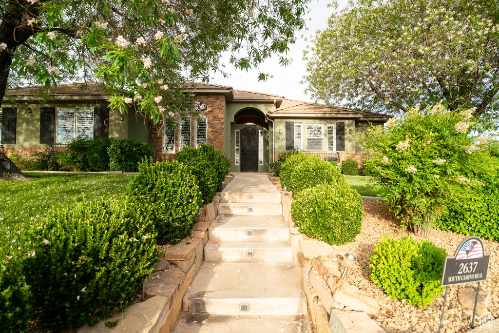 View of front of house with stucco siding and a tiled roof